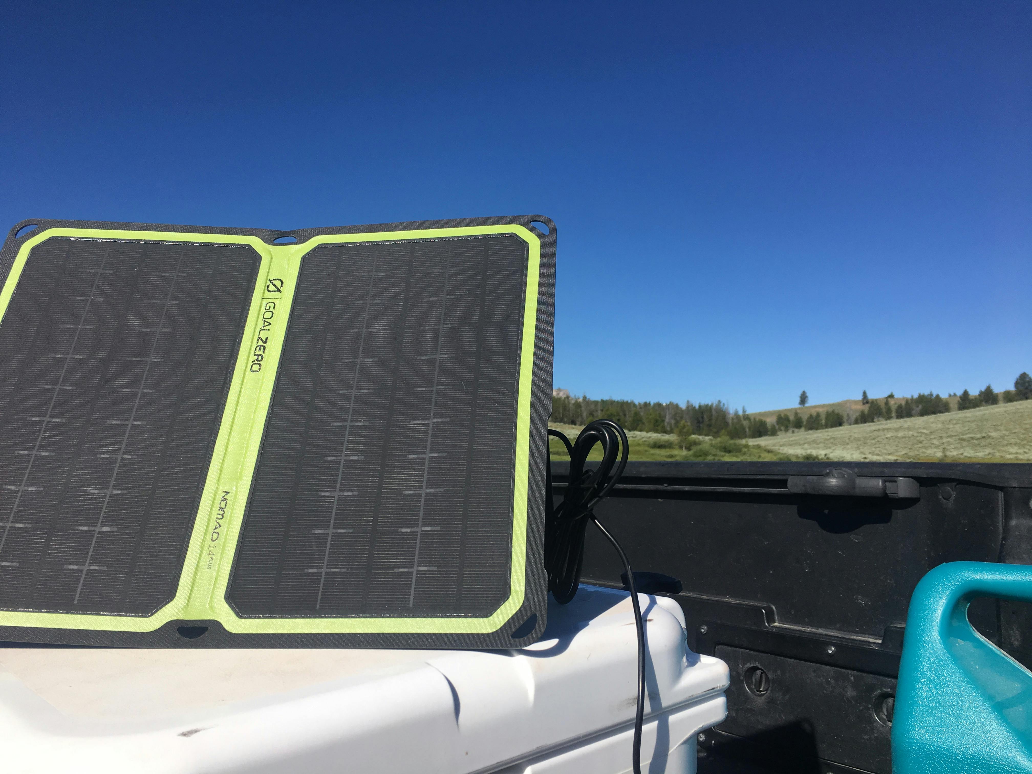 A solar panel on a cooler with a mountain in the background. 
