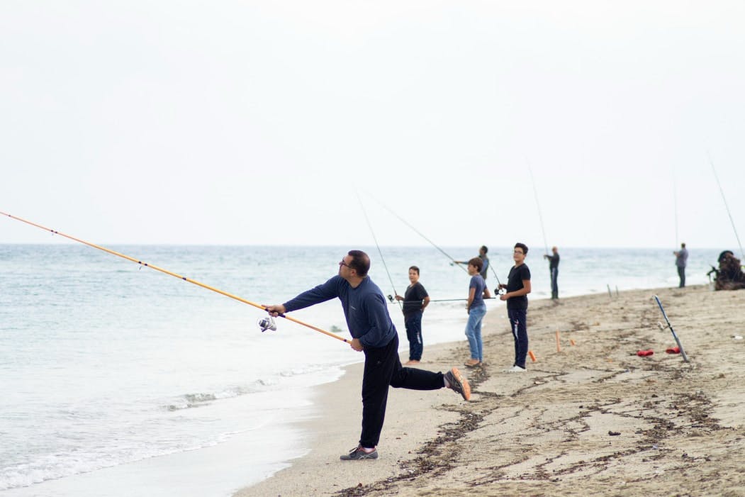 A group of people fishing from the beach