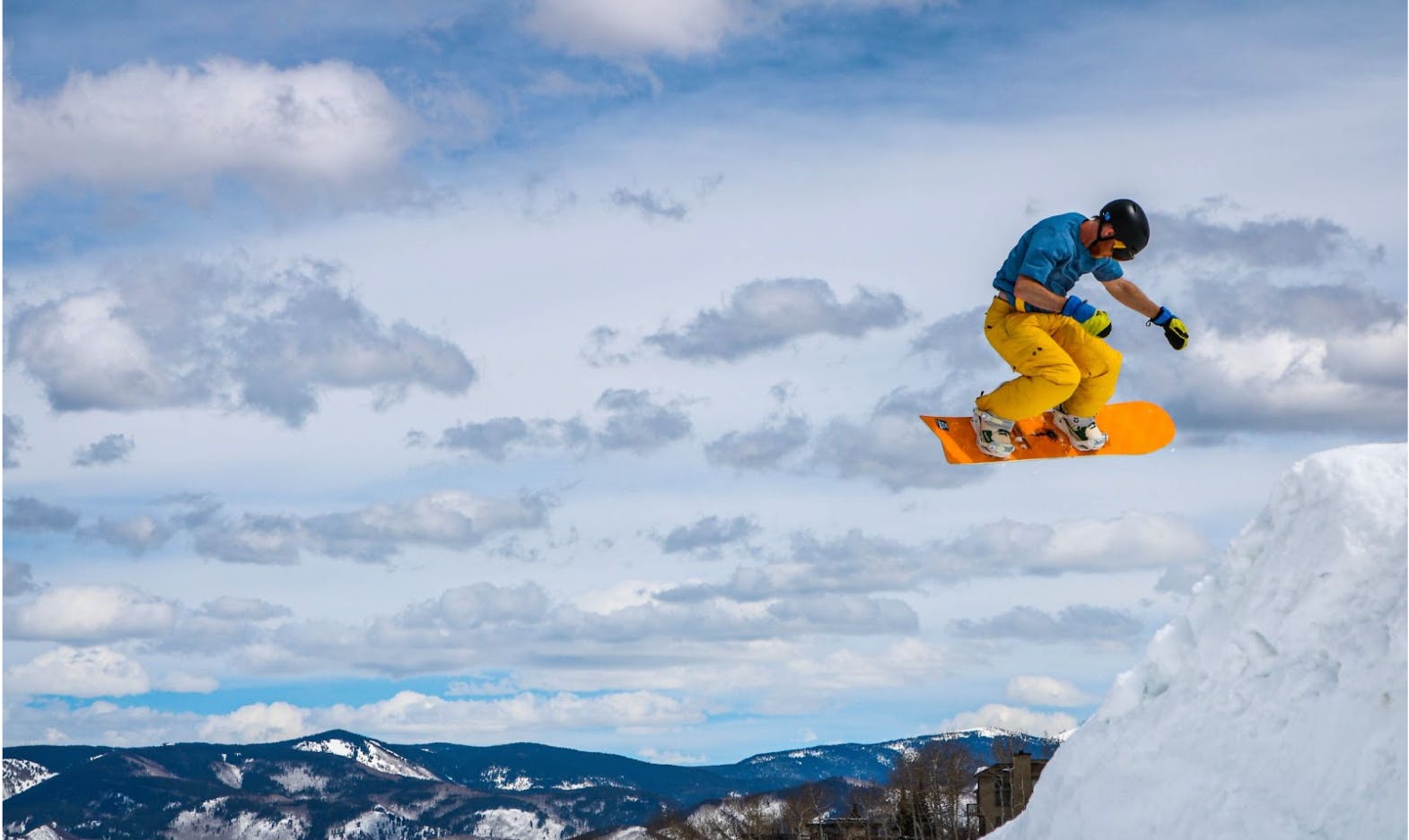 A snowboarder goes off a jump.