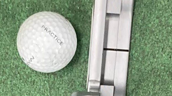 The Odyssey White Hot OG #1 CH Putter in front of a golf ball. 