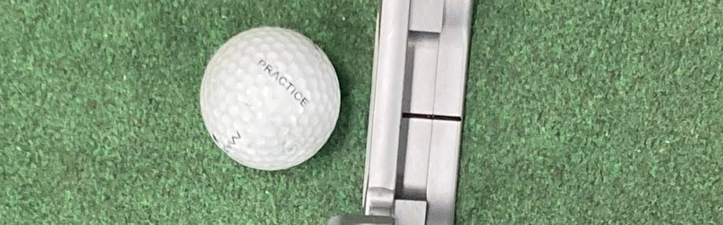 The Odyssey White Hot OG #1 CH Putter in front of a golf ball. 