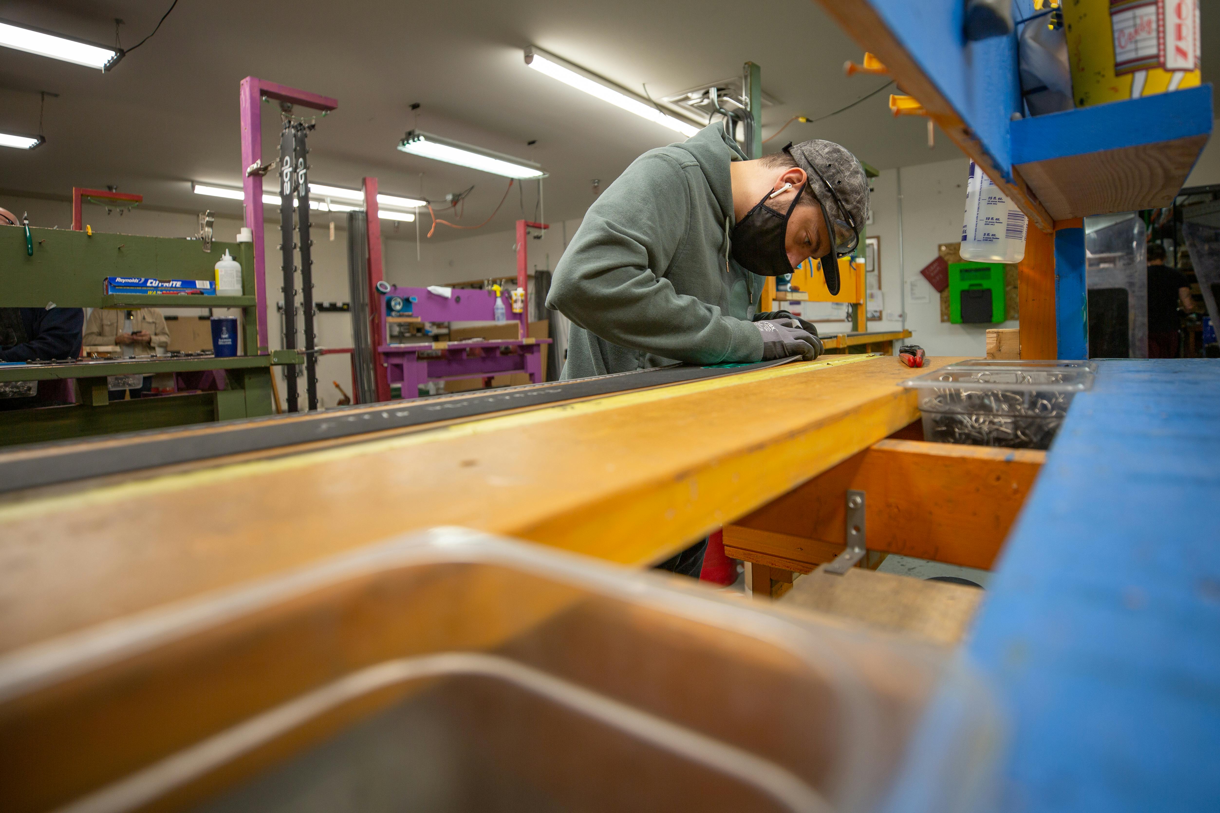 A worker building a DPS ski in the factory
