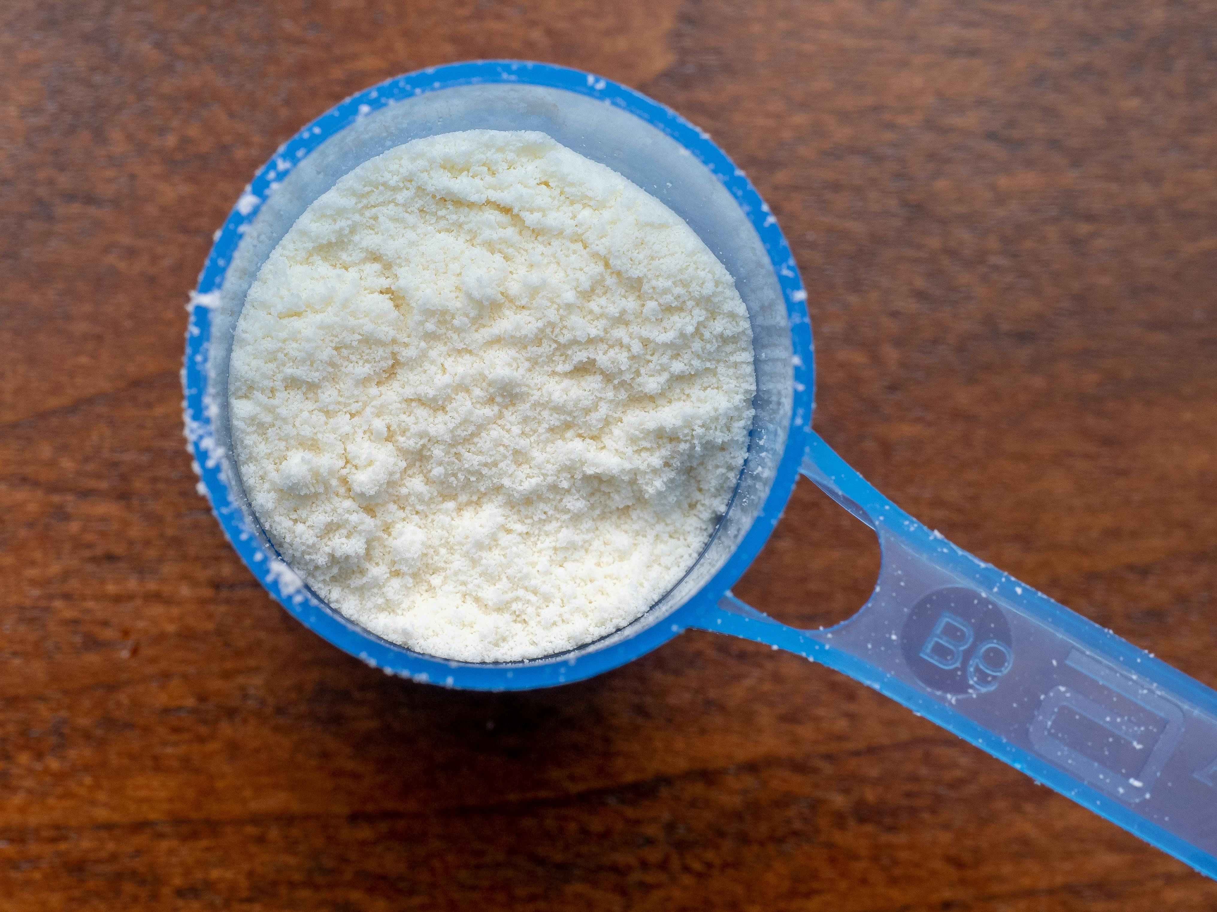 Powdered baby formula sits in a scoop. 