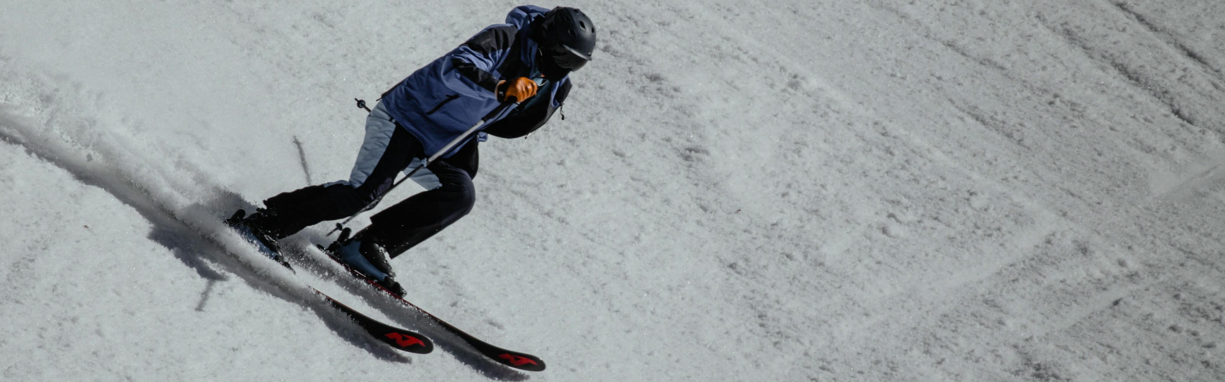A skier turns down a snowy slope with his Nordica Skis. 