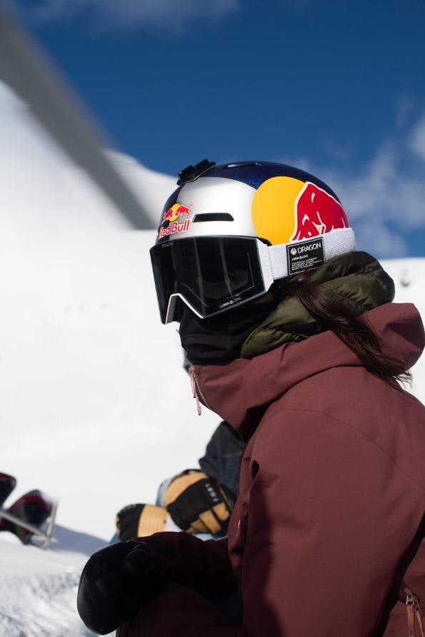 Tatum Monod looks to the side while wearing a Red Bull helmet and Dragon Optics goggles. 