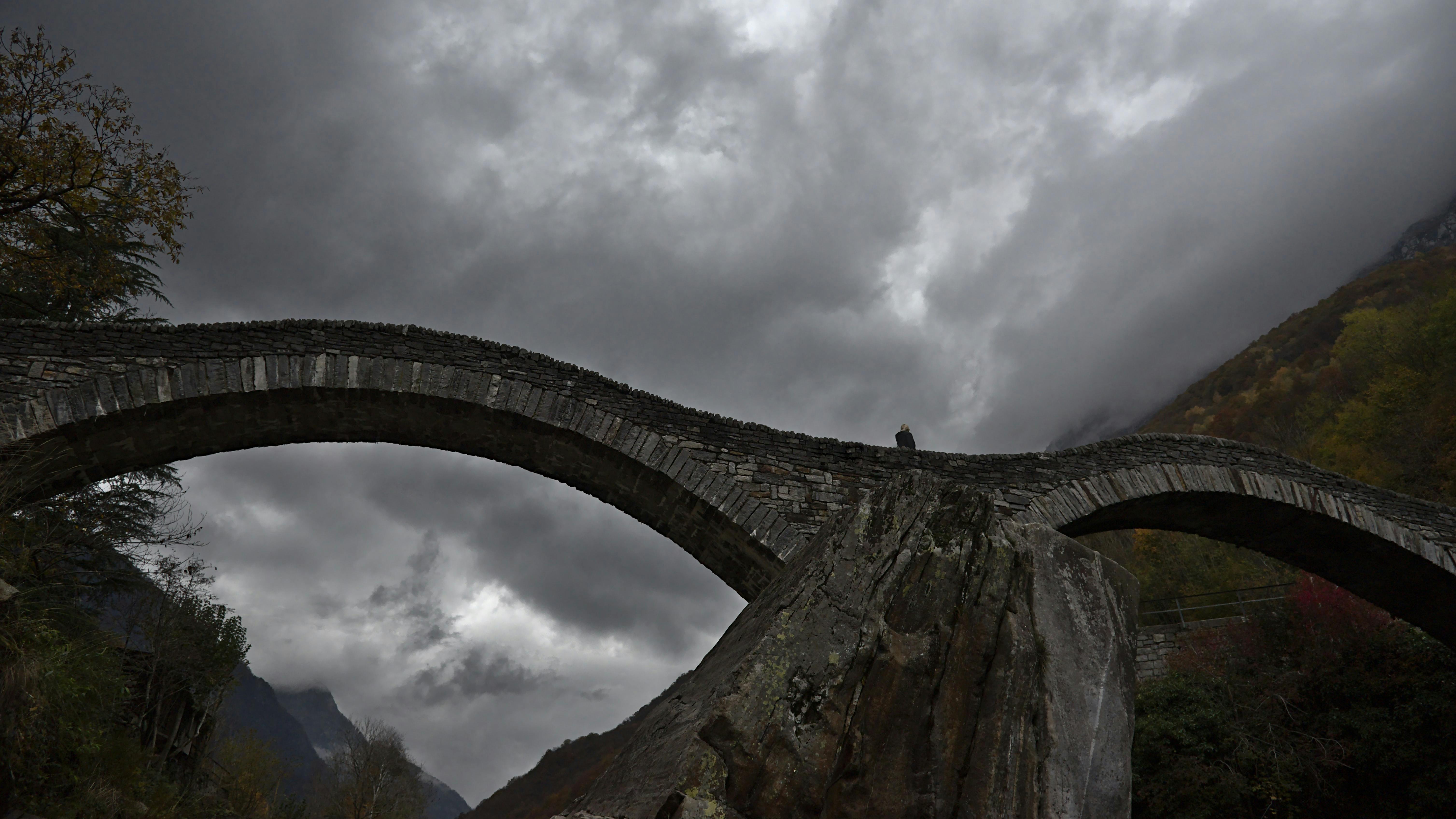 Looking up at a bridge against an ominous, cloudy, grey sky