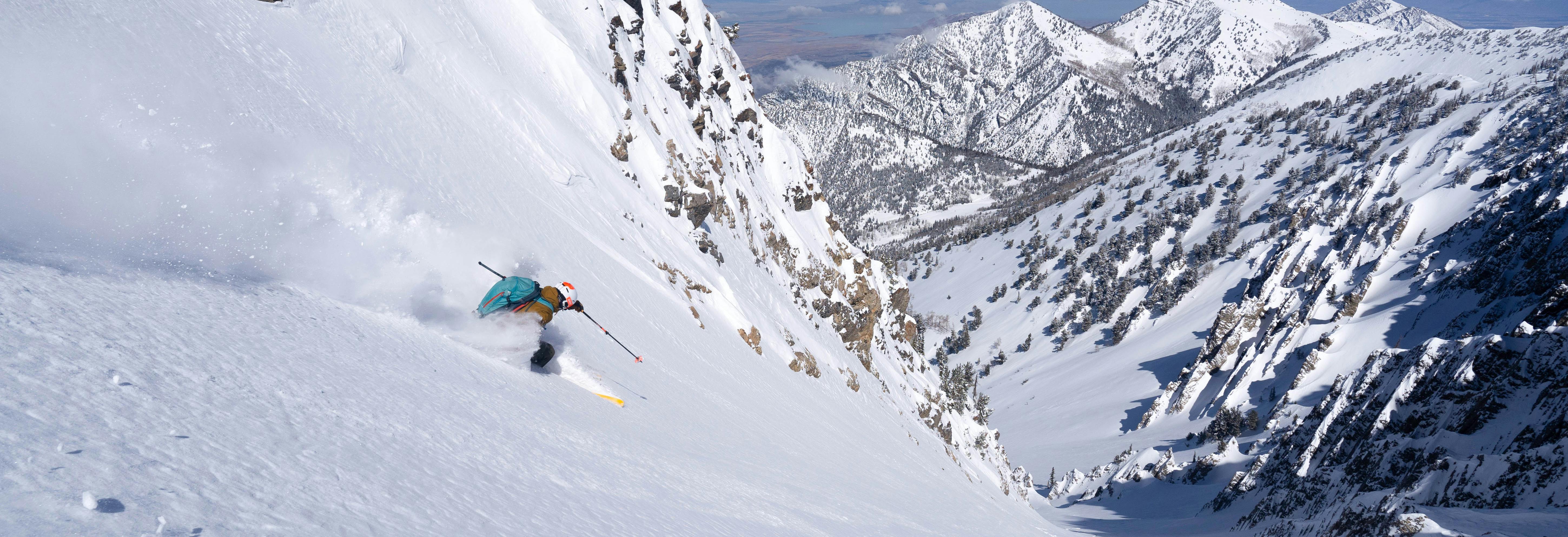 A man making a ski turn down a chute.