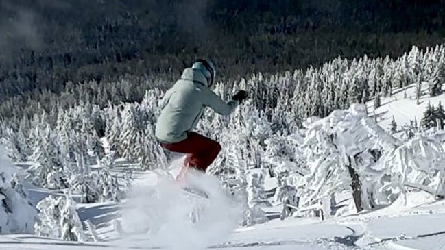 A snowboarder getting air on a snowboard. 