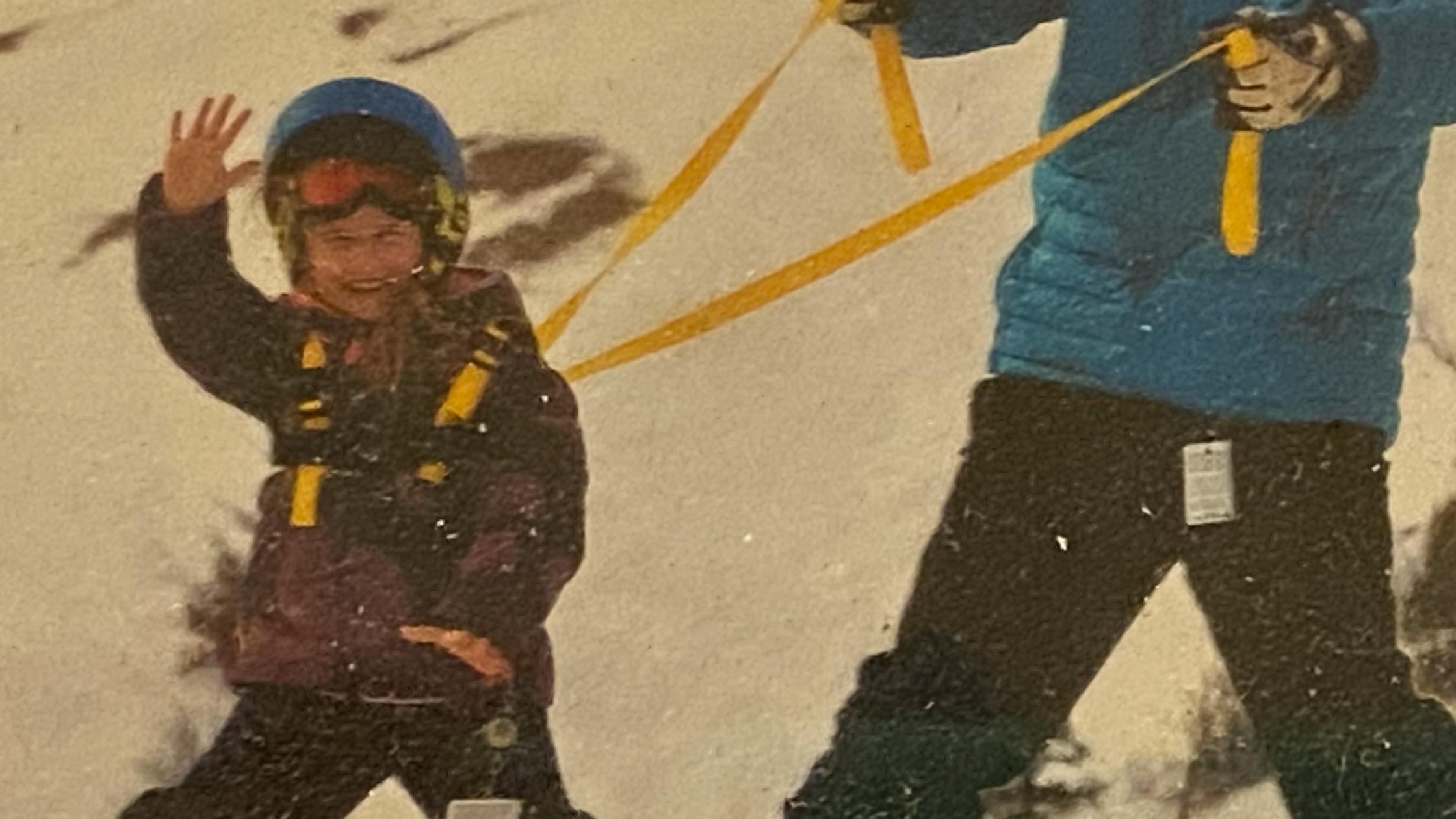 An old photo of Abe on a ski harness held by his dad