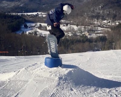 A snowboarder hits a park feature.