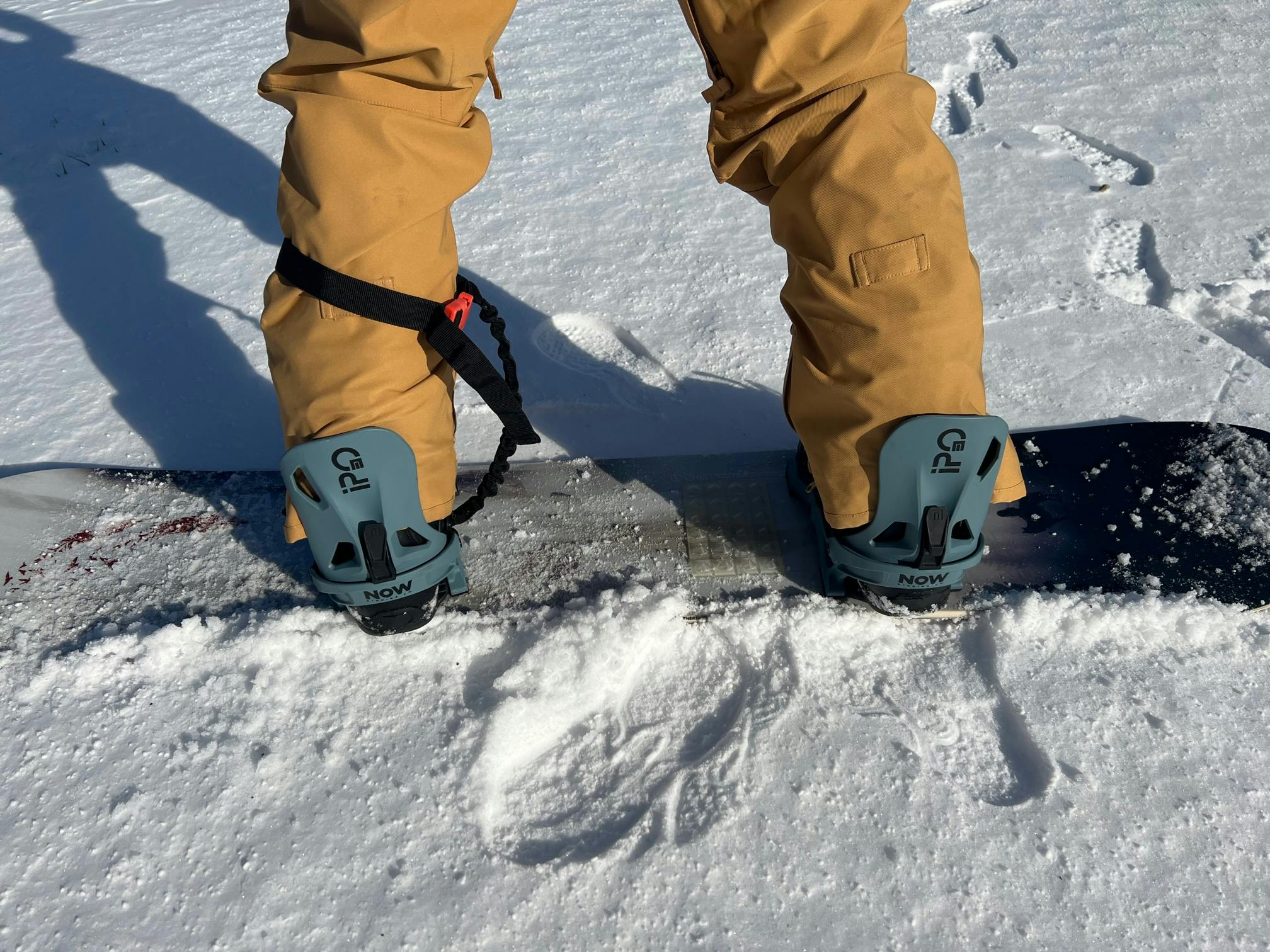 A snowboarder with the  Now Ipo Snowboard Bindings.