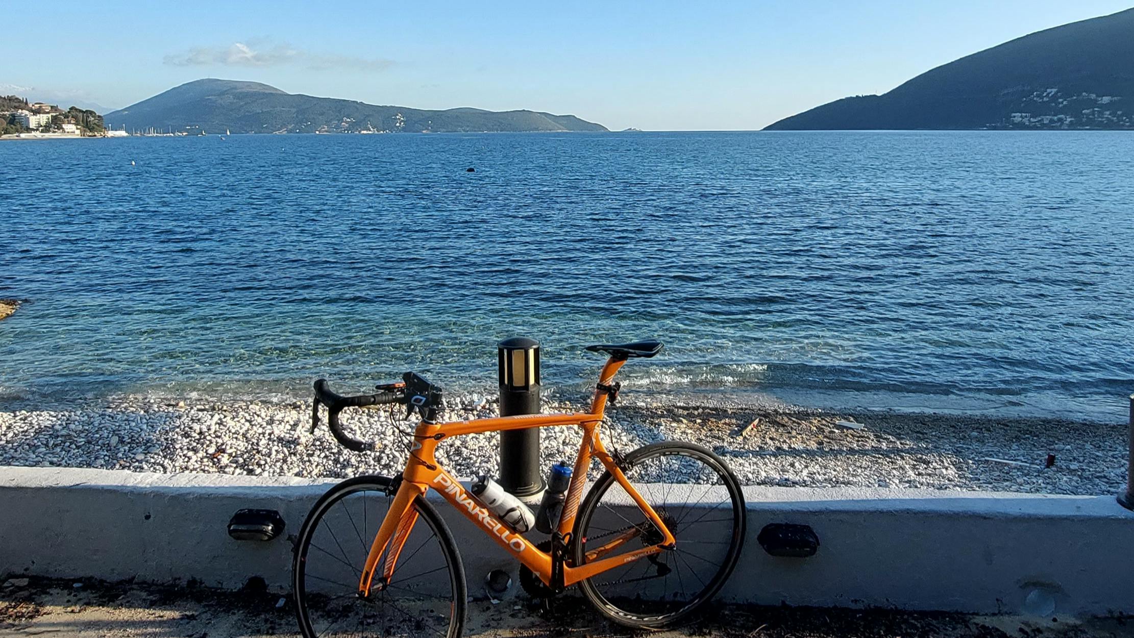 Bike in front of a huge lake and some mountains in the distance. 