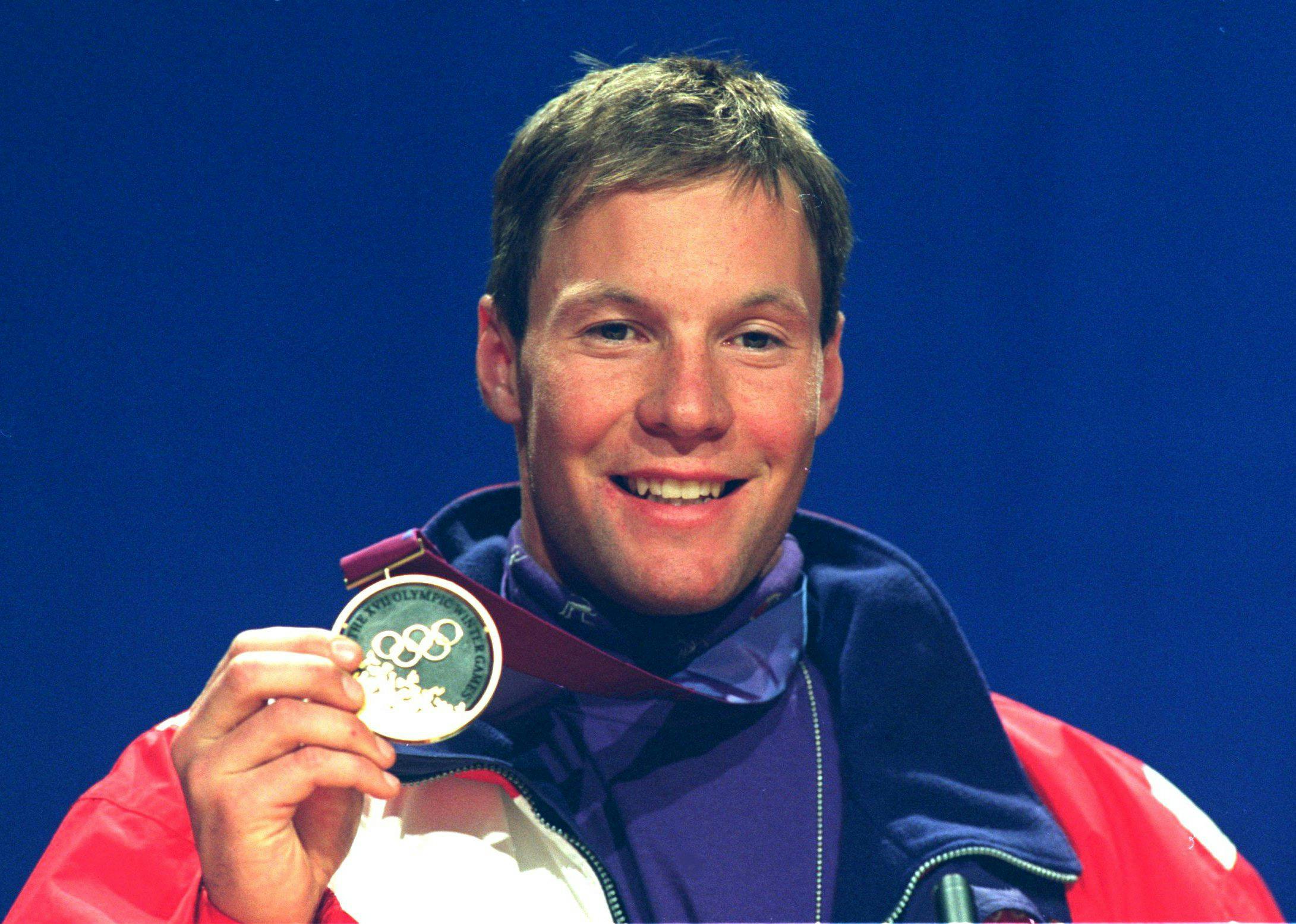 Tommy Moe holds up a gold medal