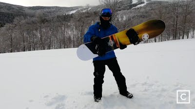 Curated expert Franco DiRienzo holding the Never Summer Harpoon snowboard