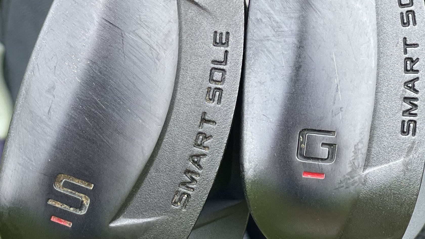 Two wedges in a golf bag.