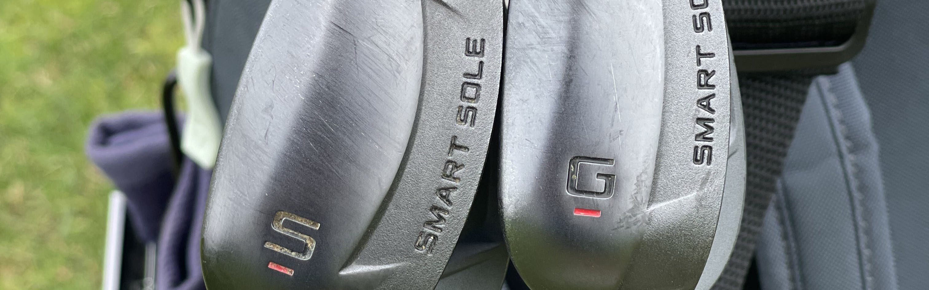Two wedges in a golf bag.
