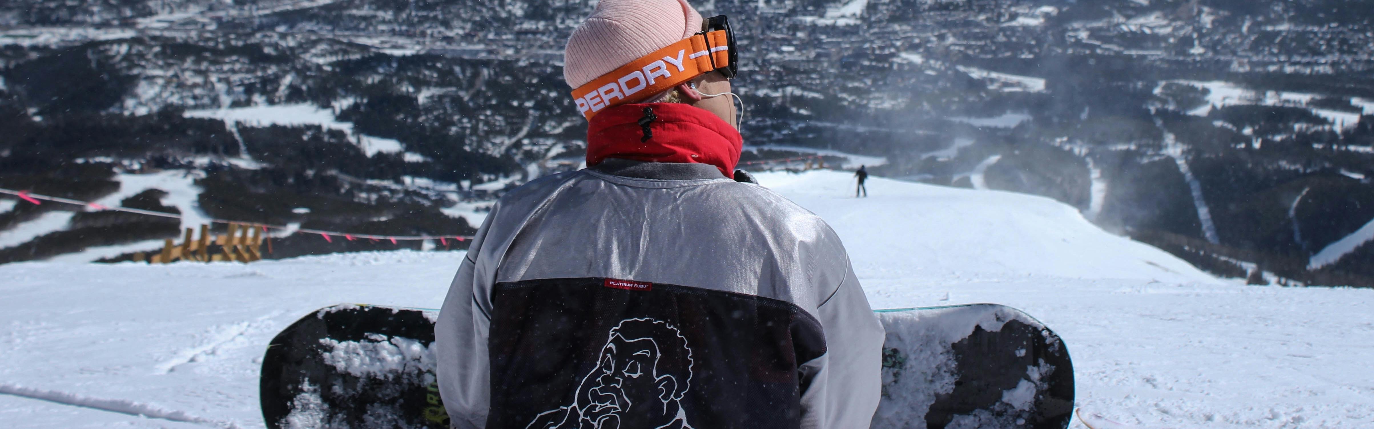 A snowboarder sitting at the top of the slope