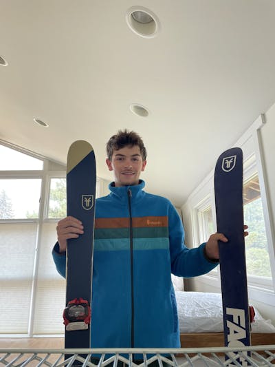 A man holding the Faction CT 1.0 skis. 