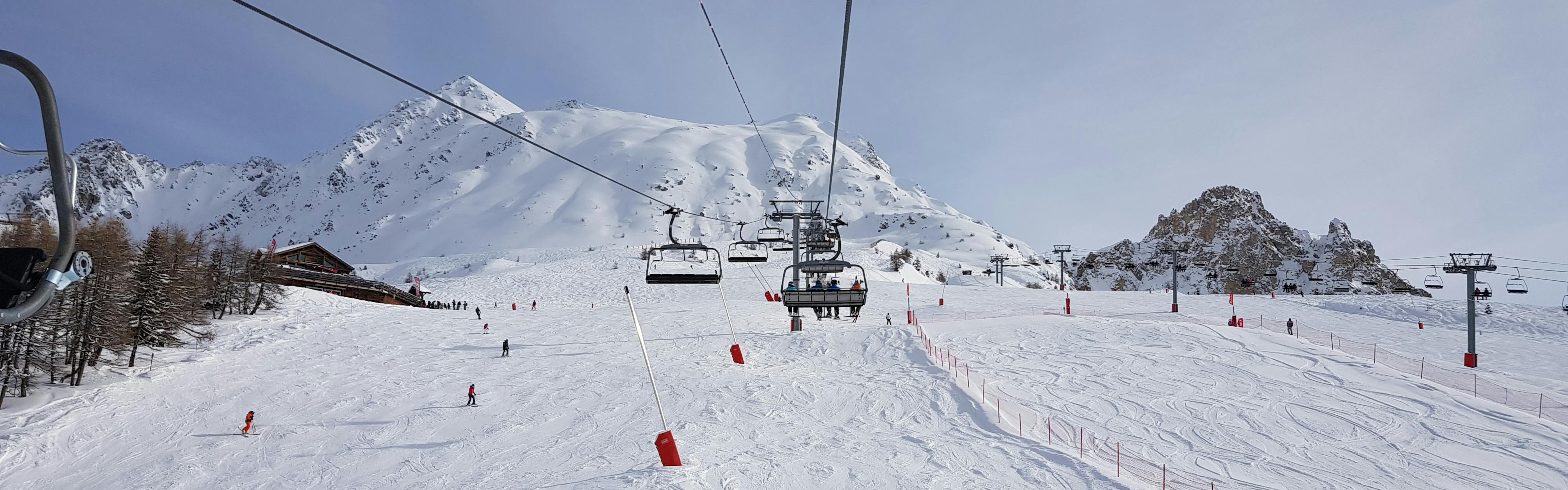 A chairlift moves across a ski hill