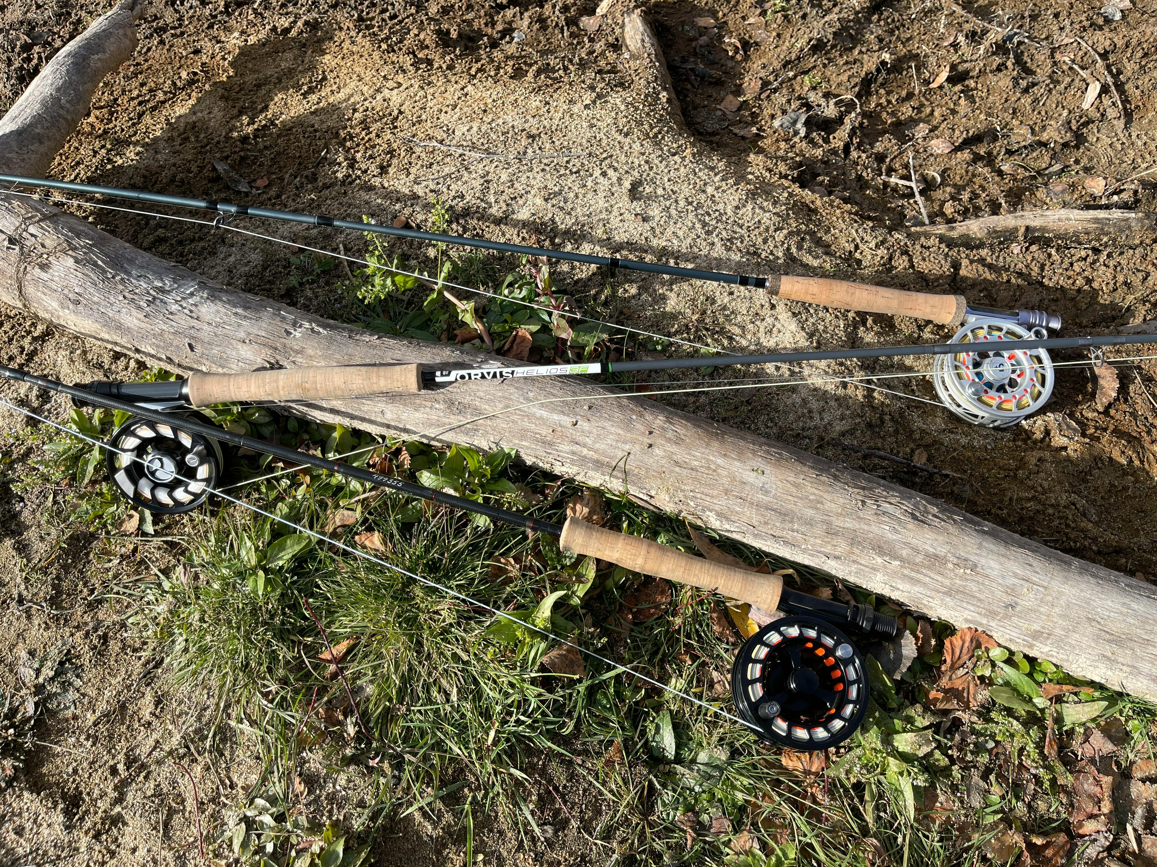Three fly rods lie on the ground.