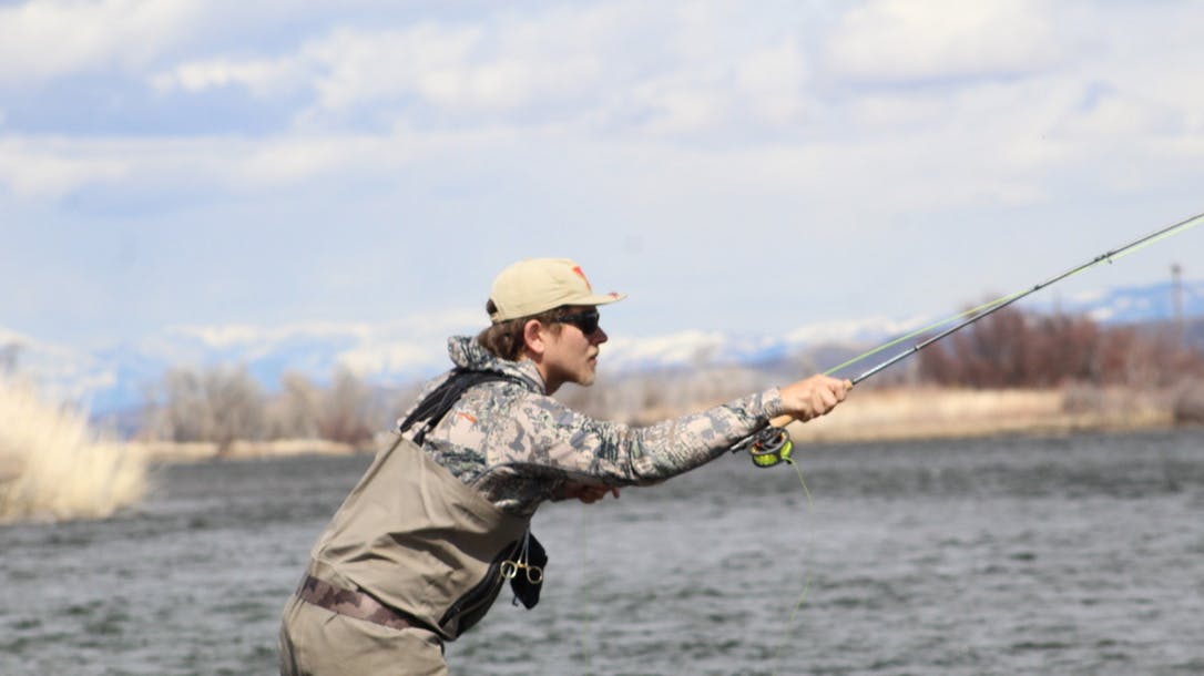 Close-up of a man fly fishing in traditional gear.