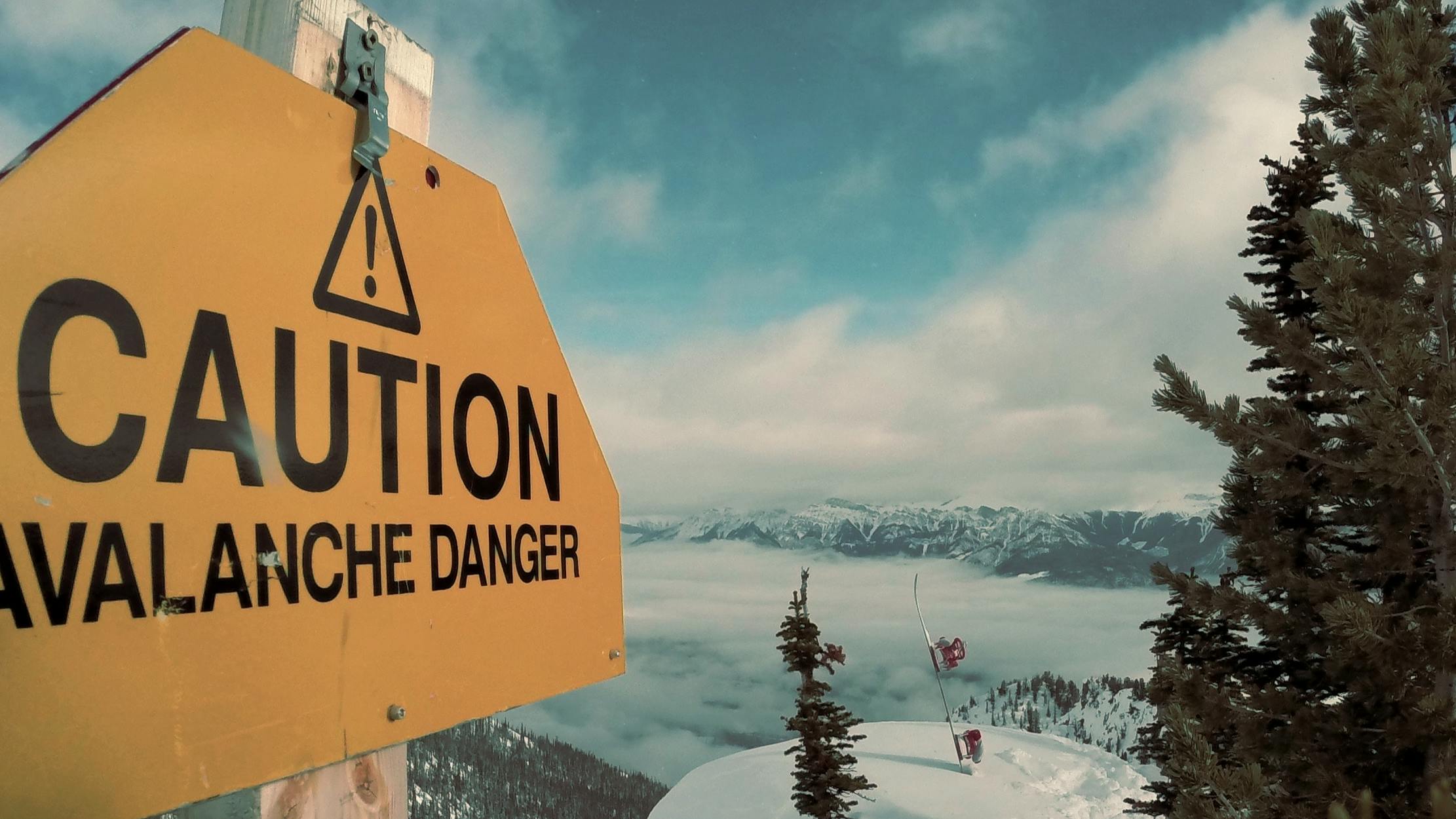 A sign reading "caution avalanche danger". 