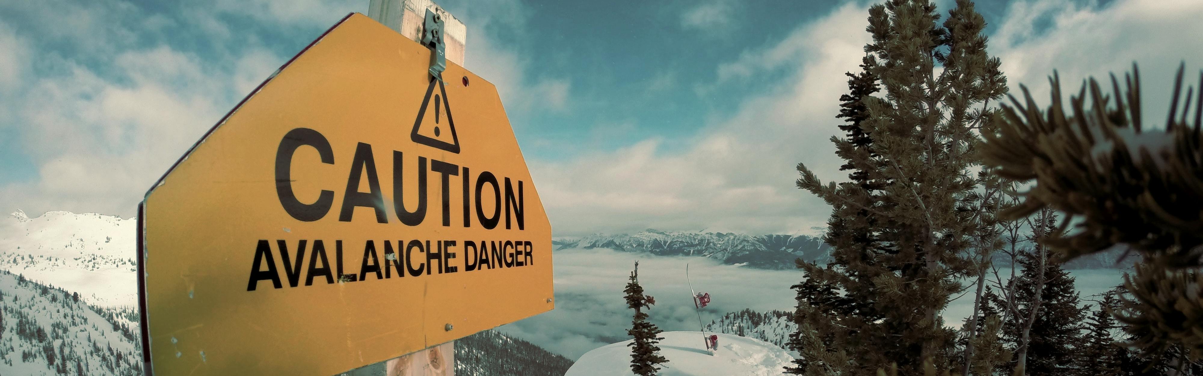 A sign reading "caution avalanche danger". 