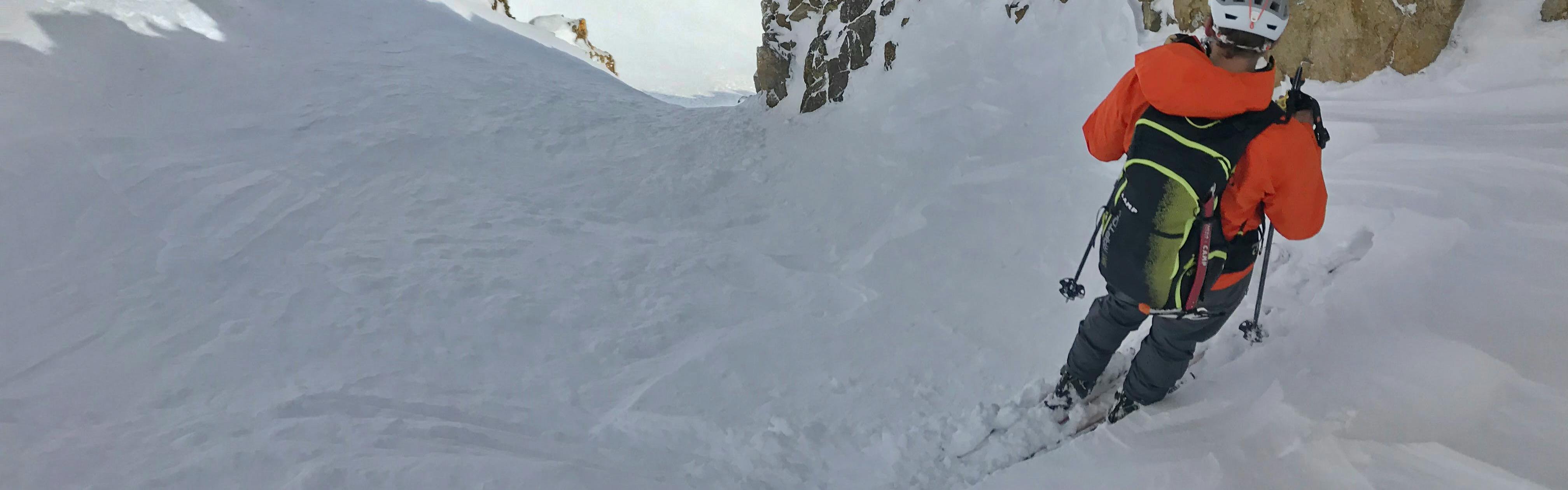 A skier at the top of a couloir. 