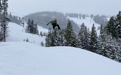 A snowboarder hitting a jump.