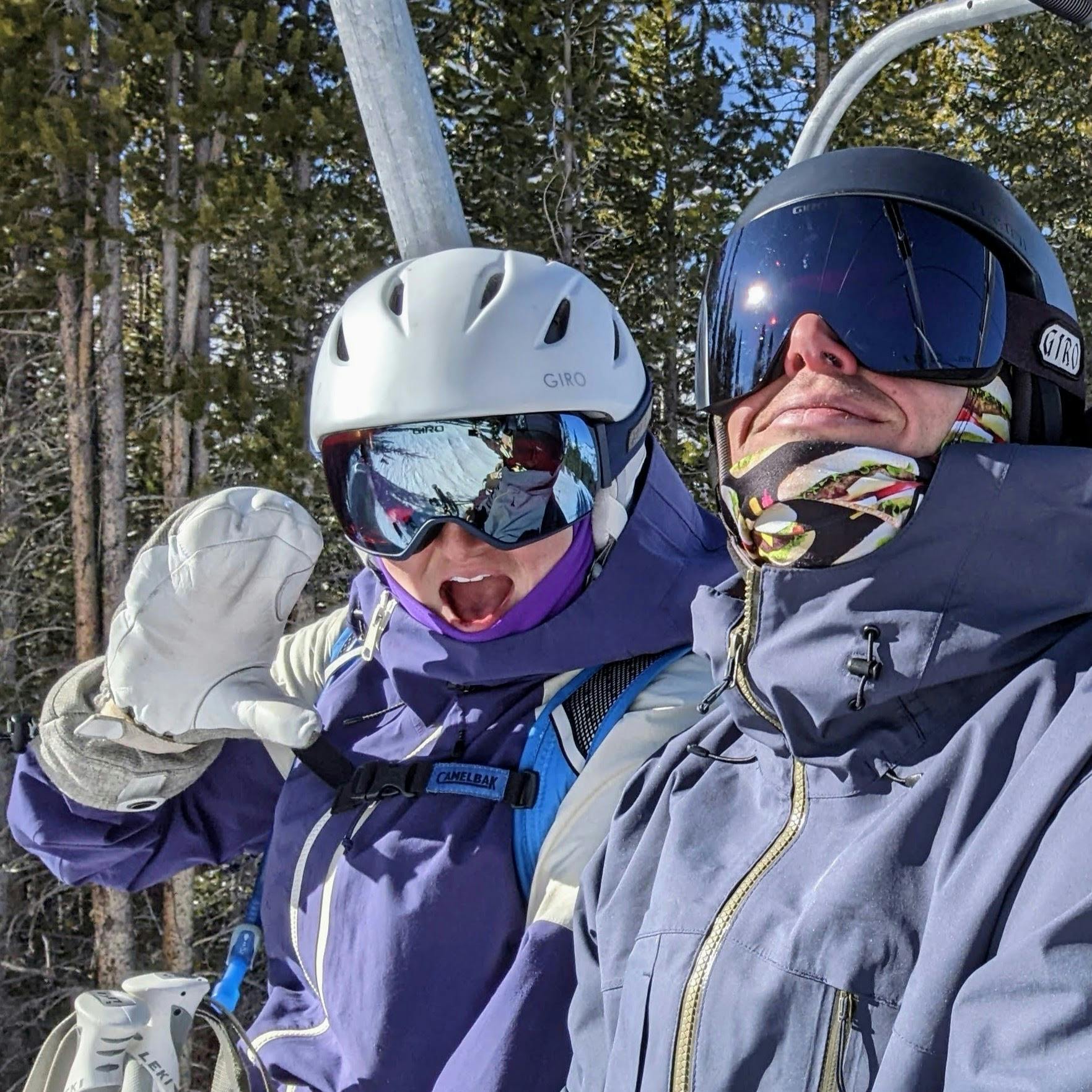 Two people in ski gear sitting on a chair lift.