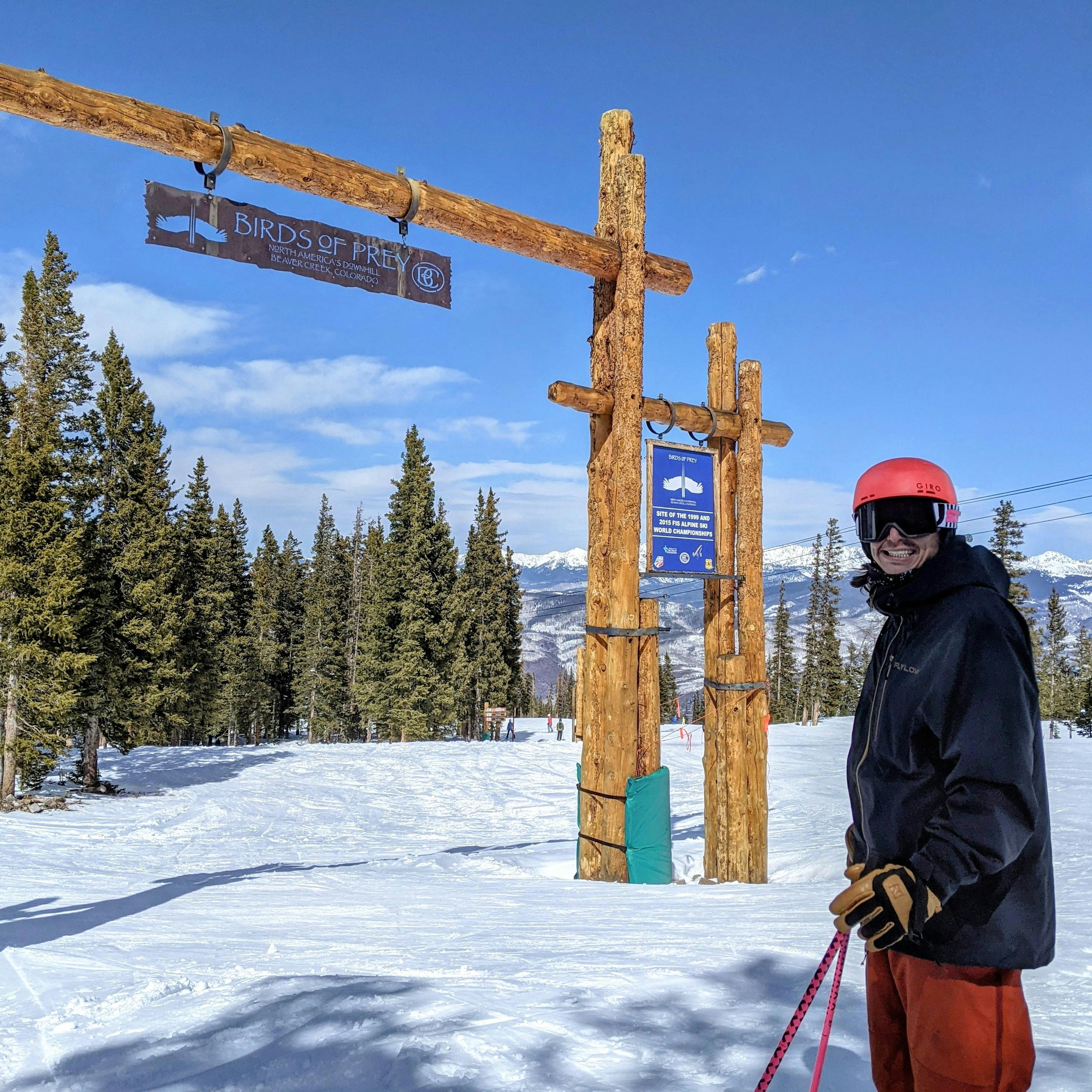 A skier standing under a sign that reads "Birds of Prey". He is wearing the Flylow Men's Knight Shell Jacket.  
