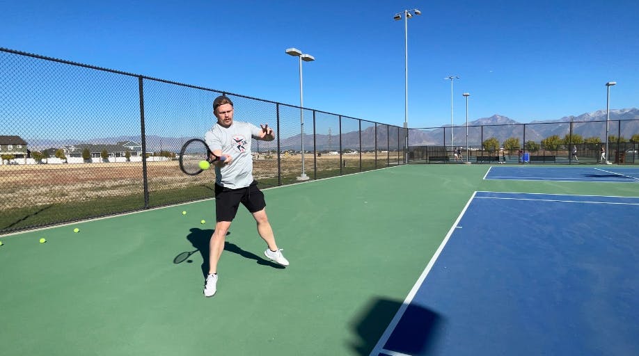 A tennis player hitting a ball with the Wilson Pro Staff 97 V13.0 Racquet · Unstrung.