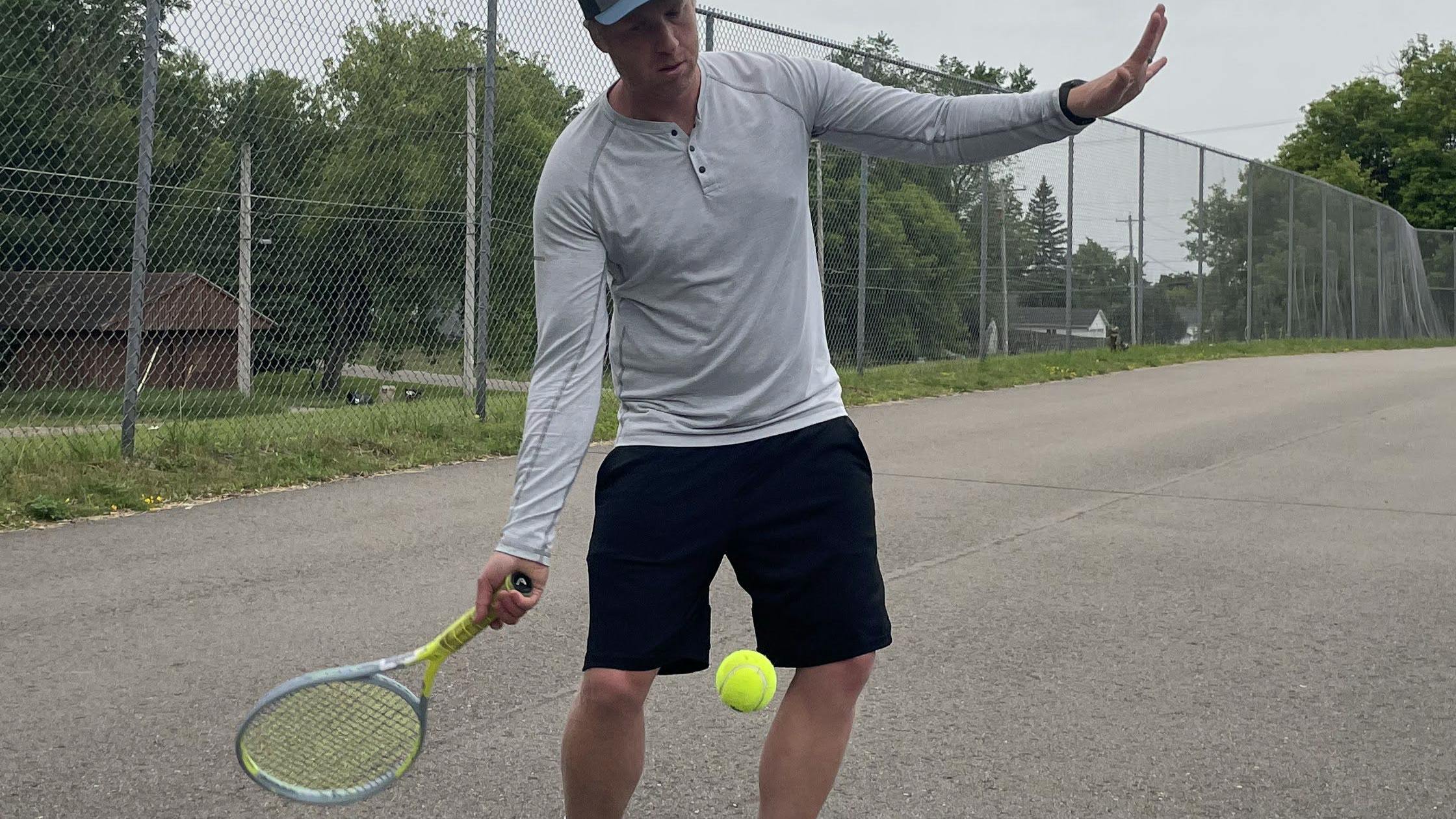 A tennis player takes a swing at a tennis ball with the Head Graphene 360+ Extreme MP Racquet.