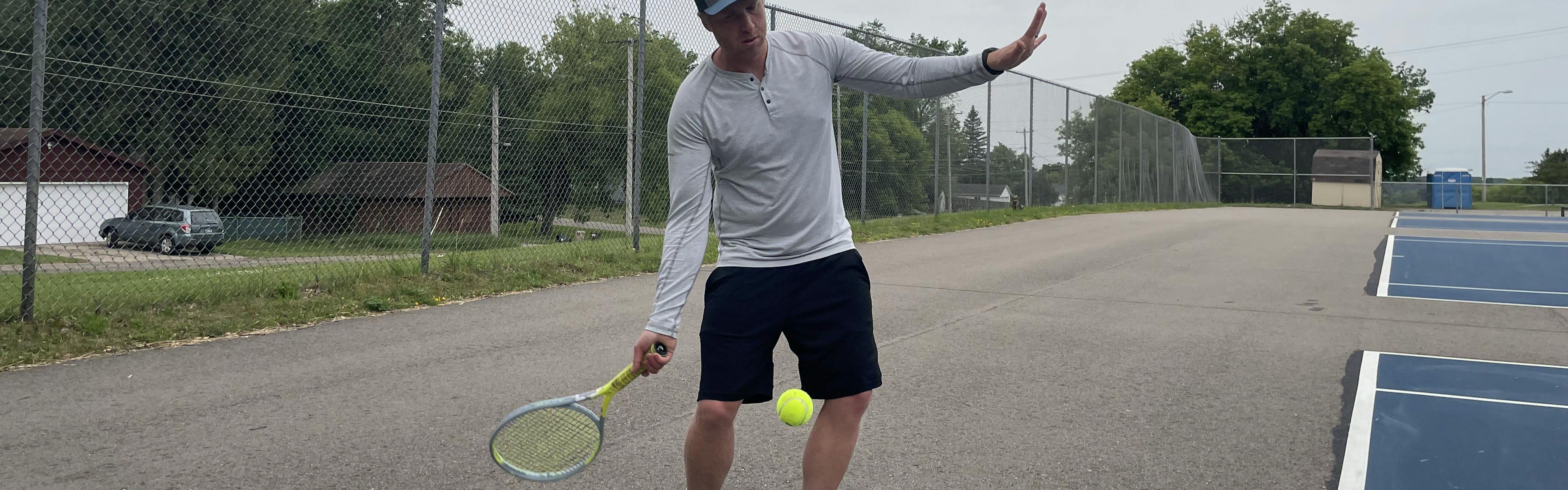 A tennis player takes a swing at a tennis ball with the Head Graphene 360+ Extreme MP Racquet.