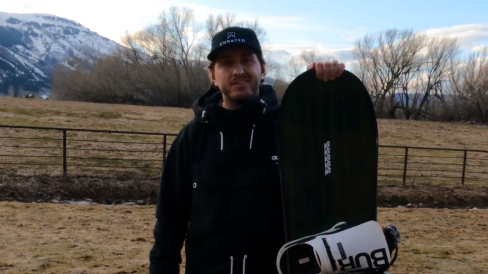 A man holding the K2 Instrument Snowboard.