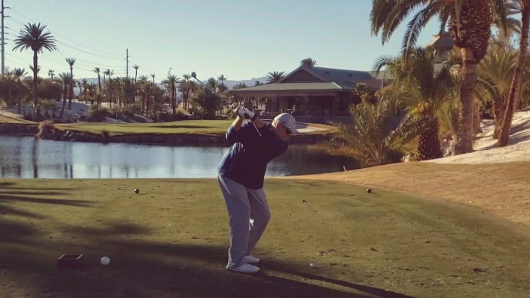 A golfer swinging the Mizuno Pro 223s.