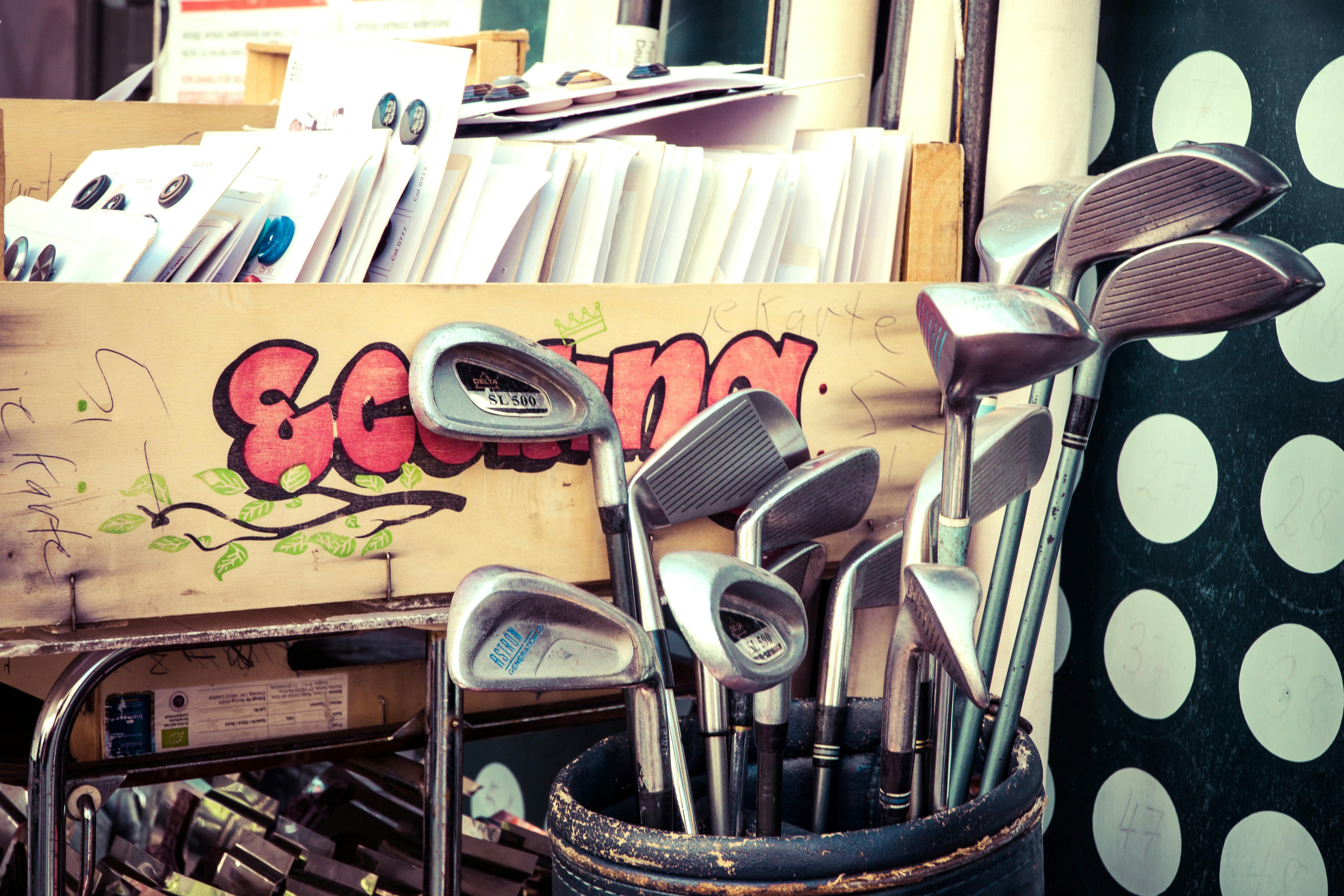 Golf clubs with a box of papers in the background
