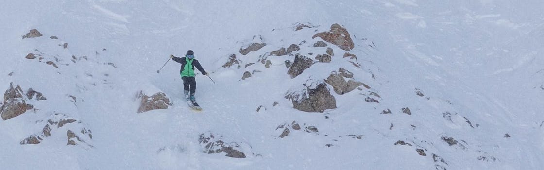Someone makes their way down a steep and rocky slope on the Dynastar M-Free 108 skis.