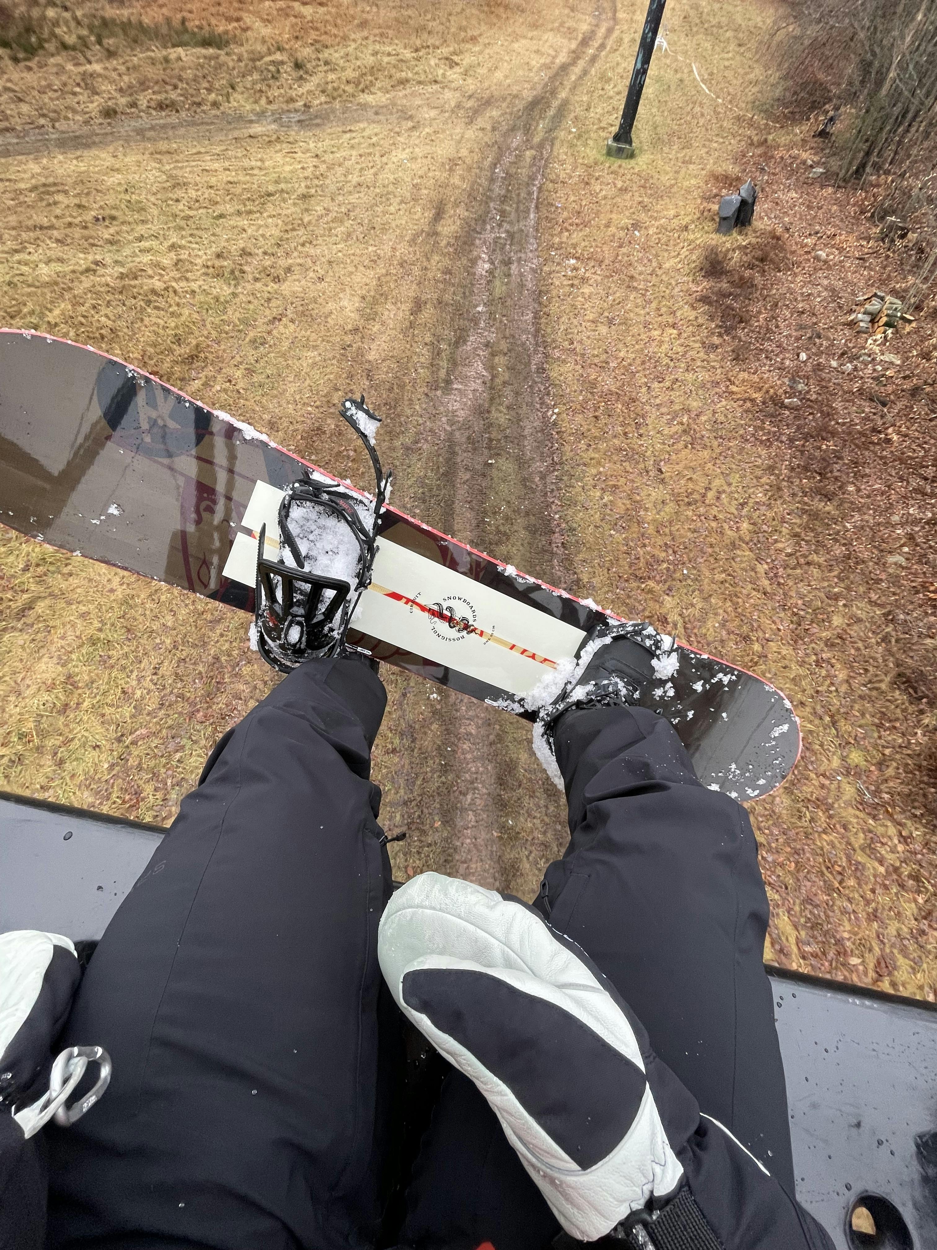 Top down view of a snowboarder on a chairlift wearing the Hestra Army Leather Extreme Mitt Men's.