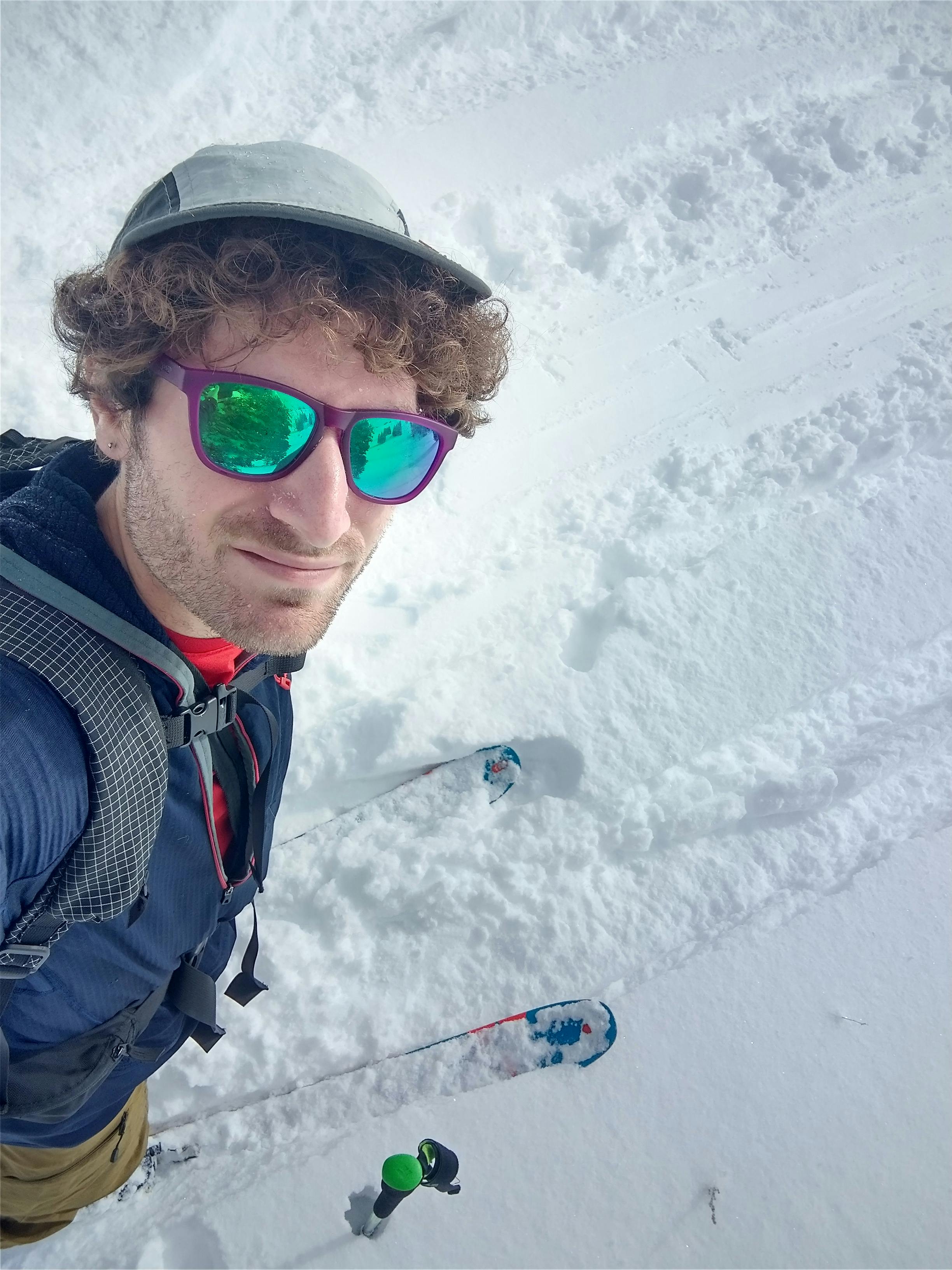 Top down selfie of a skier walking up a skin track. 