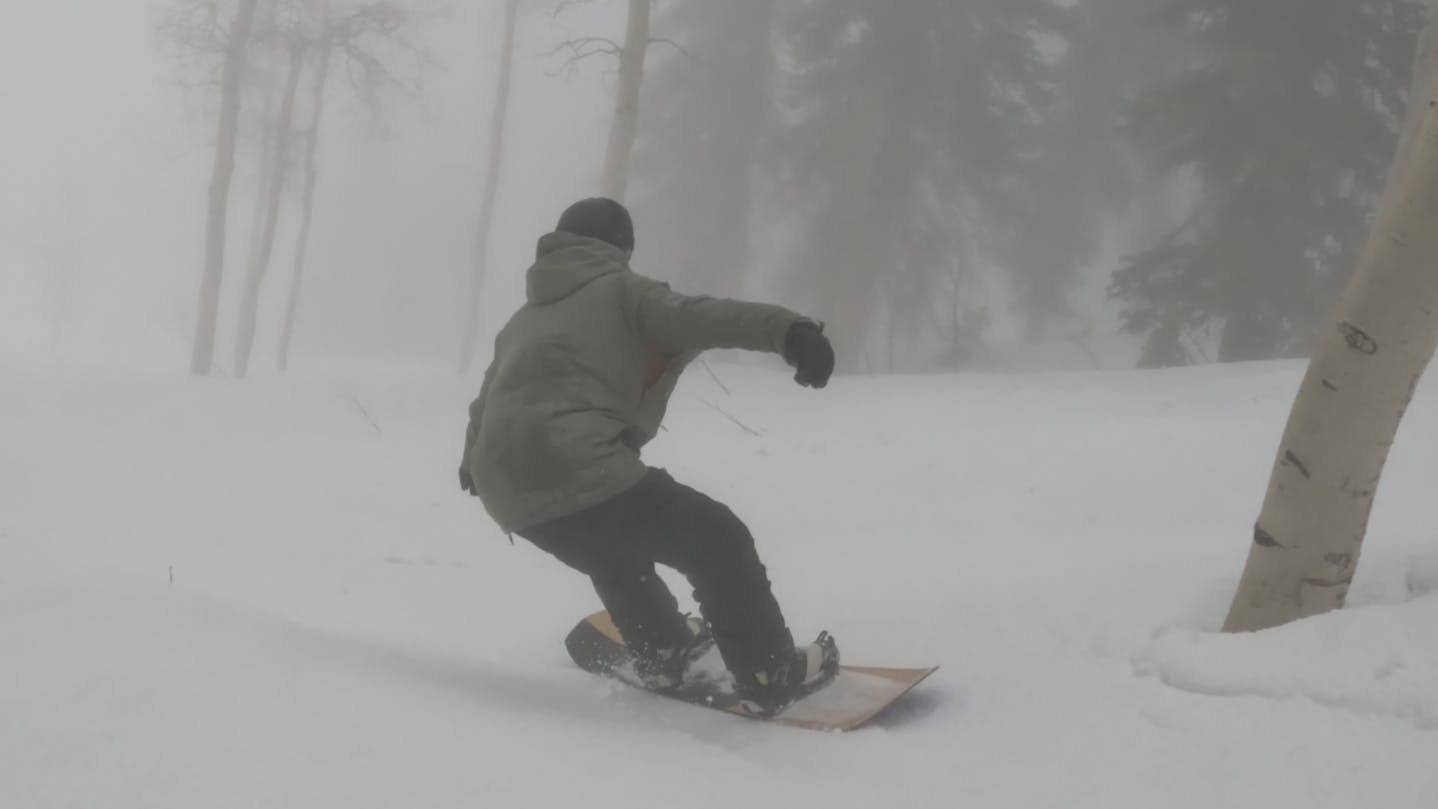 A snowboarder on the 2023 Salomon Assassin Snowboard.