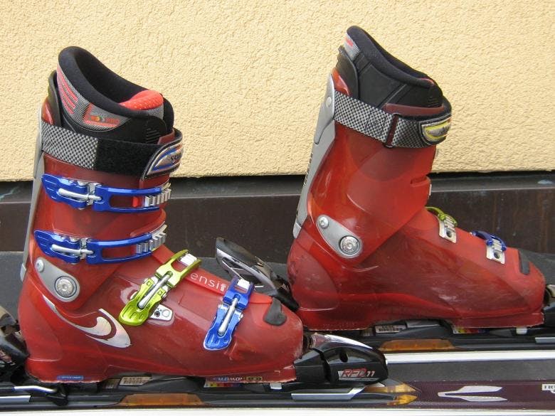 A pair of ski boots locked into some bindings. 