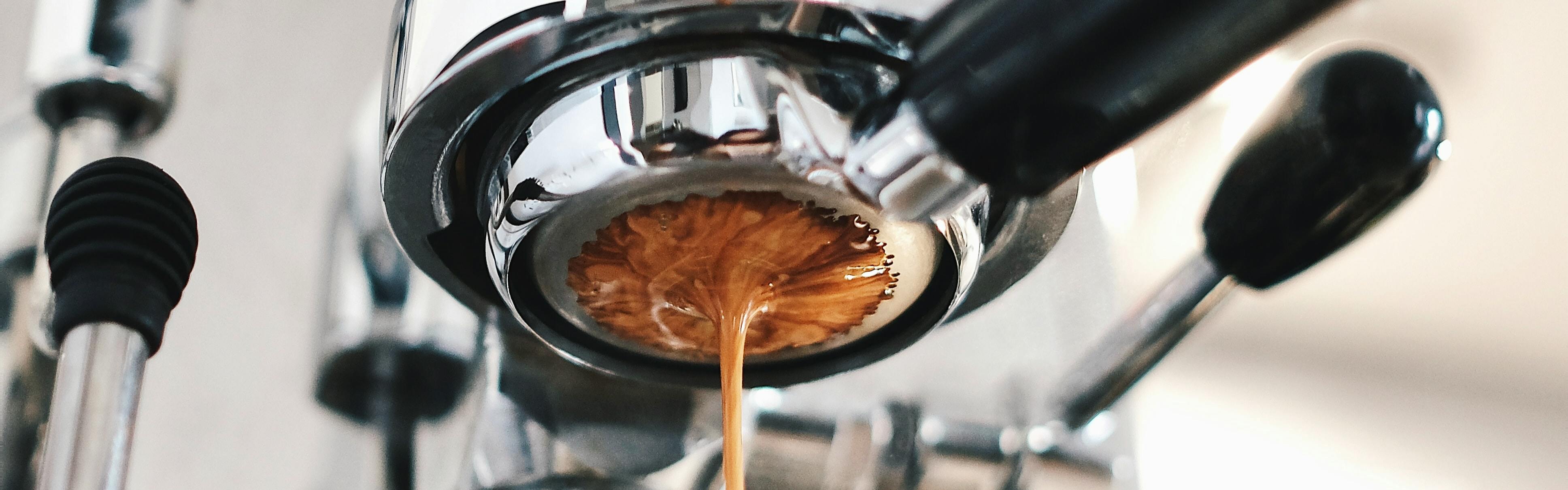 Coffee being brewed by the machine flowing through portafilter