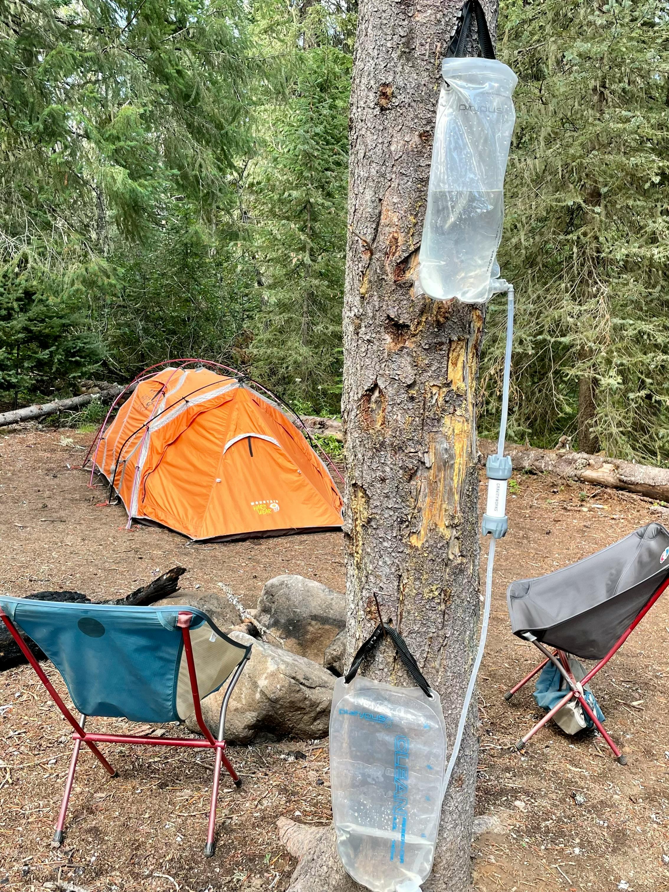 The author's Platypus GravityWorks system hanging from a tree with their campground set up in the background.
