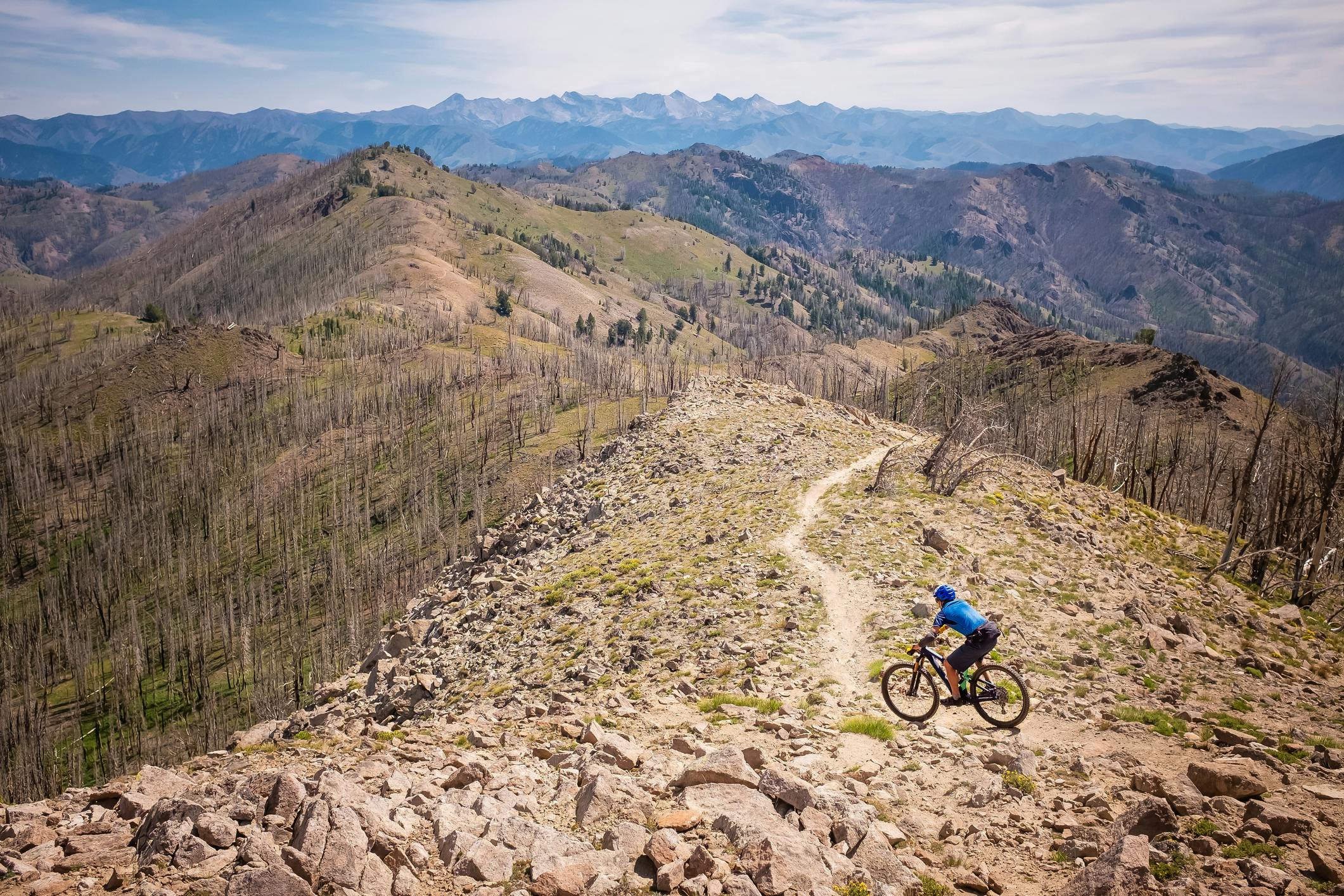 A person on a mountain bike navigates their way down a rocky trail