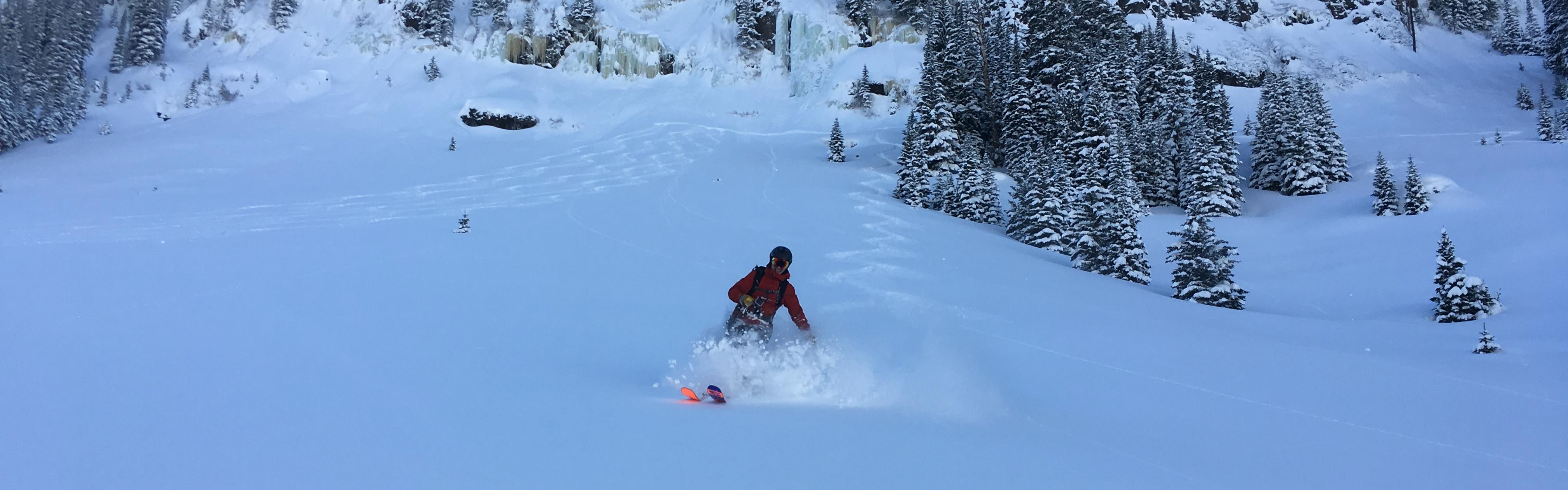 A skier gliding down a slope blanketed with powder snow