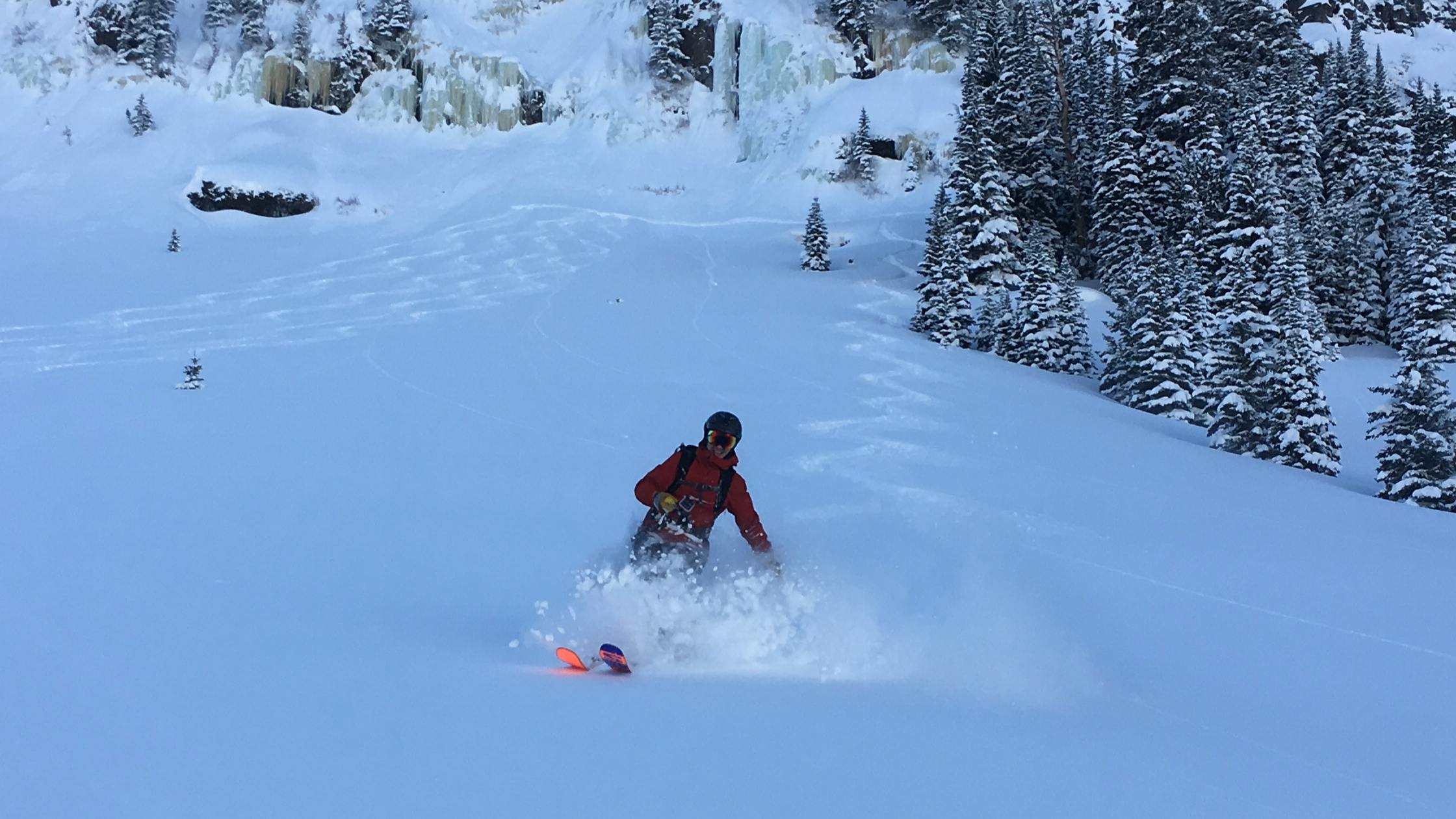 A skier gliding down a slope blanketed with powder snow
