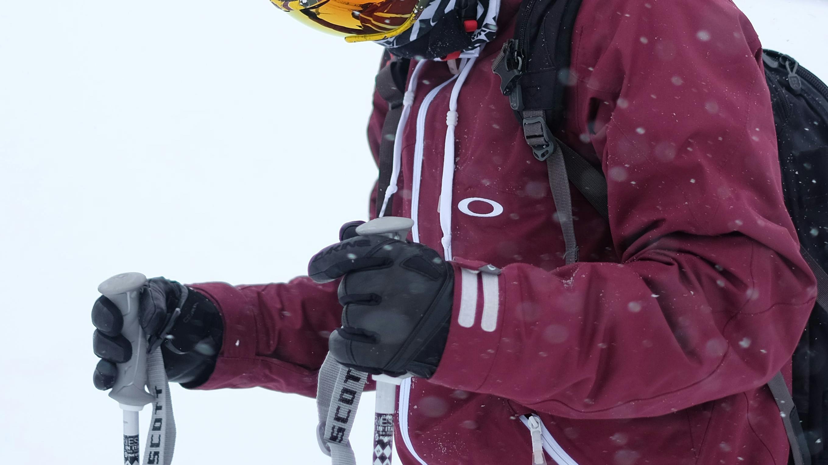 A skier holding his poles with his gloved hands. 