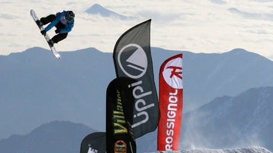 A snowboarder hitting big jump.