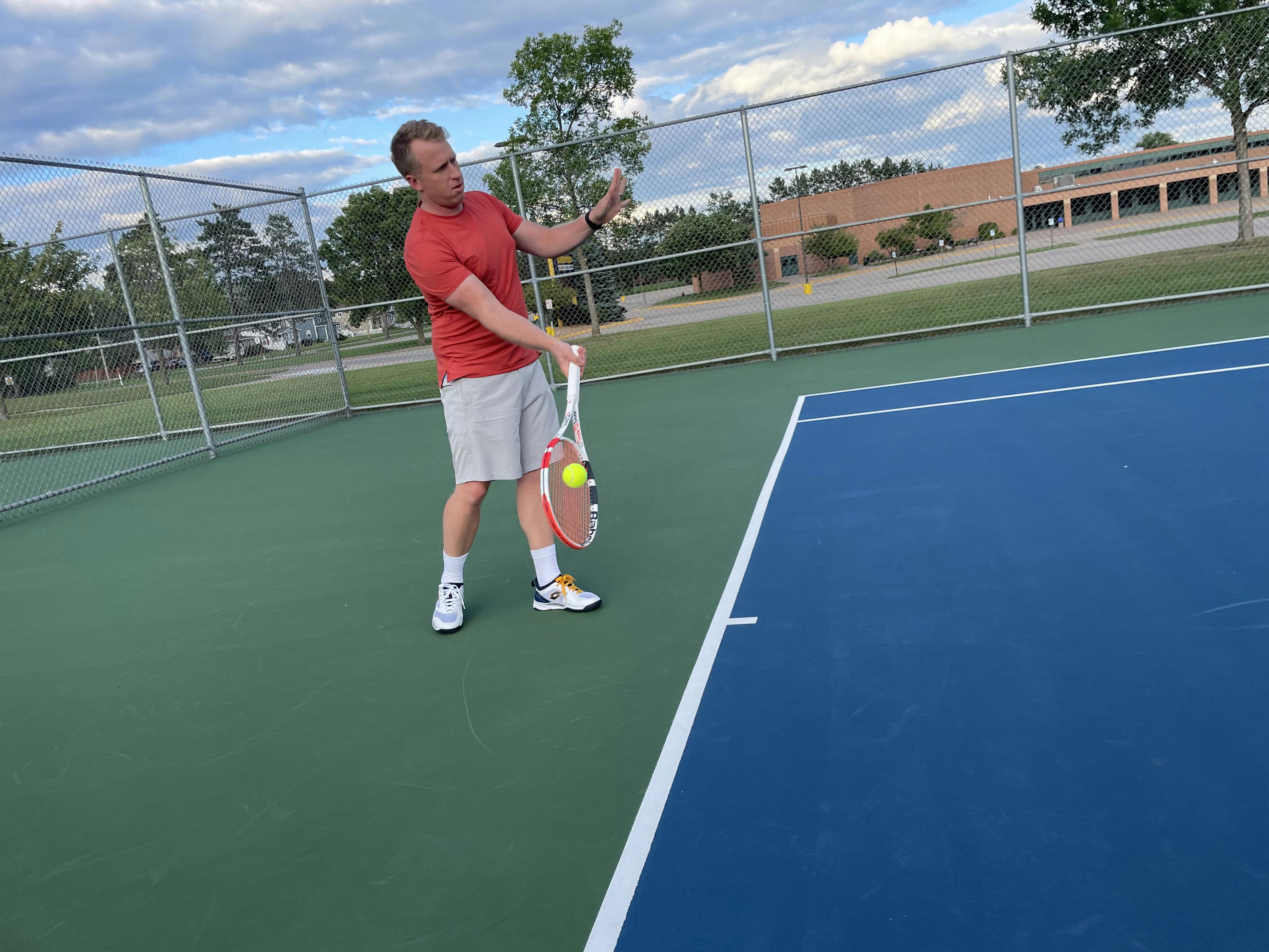 A man using the Babalot Pure Strike 18x20 racquet.